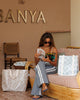 Woman reading a book in a lounge area with Sandy Weekender Tote Bag. Sandy Print - Weekender Bag - Reusable bags online | Daily bags | Shopper bags | Pouches  Hello Weekend Beige canvas handles | Beach Bags