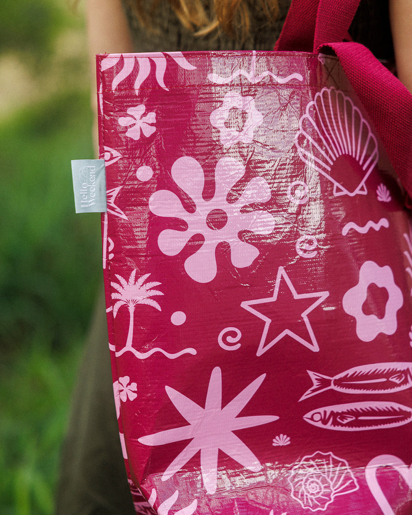 A Hello Weekend magenta tote bag with a pink and white ocean-themed pattern featuring seashells, starfish, waves, and a heart with two sets of maroon cotton canvas straps. Layla Print - Weekender Bag - Reusable bags online | Daily bags | Shopper bags | Pouches  Hello Weekend Beige canvas handles | Beach Bags