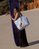 A Hello Weekend large bag with a pastel patchwork pattern featuring beach motifs like seashells, palm trees, and waves in lavender, blue, orange, and white, with light blue handles. Lizzie Print - Weekender Bag - Reusable bags online | Daily bags | Shopper bags | Pouches  Hello Weekend Beige canvas handles | Beach Bags